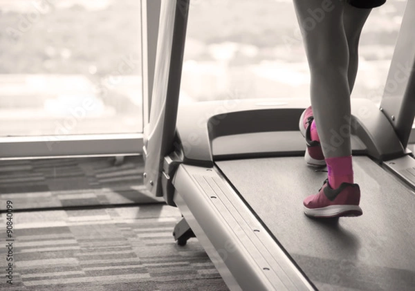 Fototapeta Woman workout on treadmil split-tone  with sepia