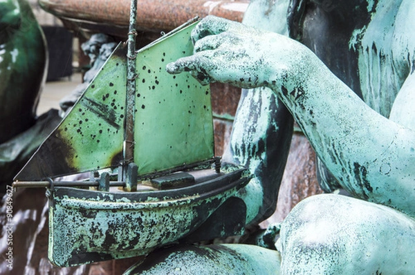 Fototapeta Statue hands hold a boat and place it on water