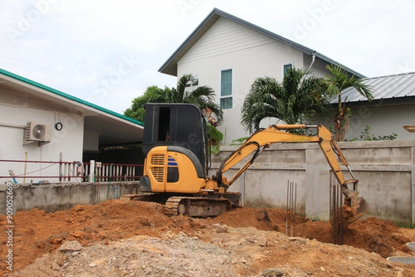 Obraz An excavator is digging soil in a construction site