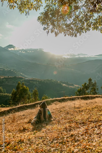 Fototapeta persona de espaldas viendo hacia el horizonte frente a una montaña en un amanecer 