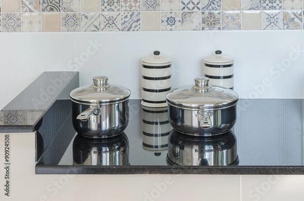 Obraz set of stainless pot on black granite counter in kitchen room