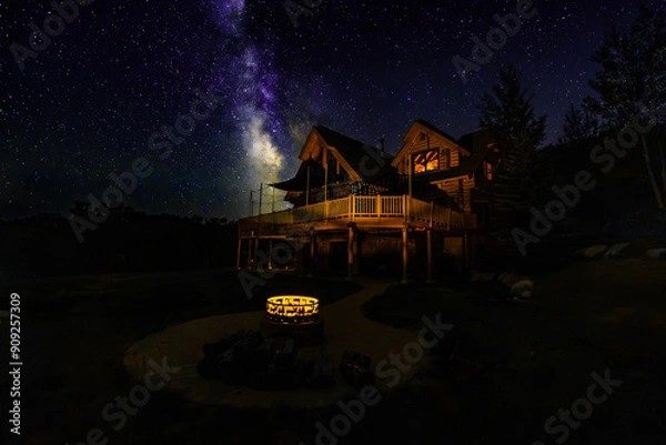 Fototapeta Log cabin under the milky way skies with a lit fire pit in Steamboat Colorado