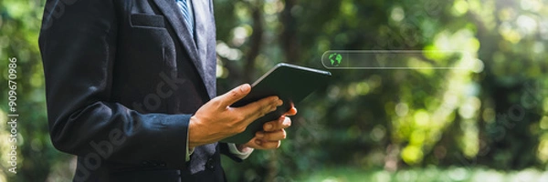 Fototapeta Business man using tablet to analyze ESG concept ,Sustainable development goal (SDGs) Ideas Globe Glass energy-based green business can limit climate change and global warming.