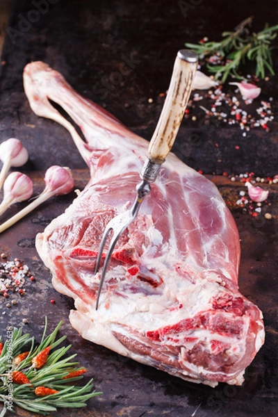 Fototapeta Raw leg of lamb with spices and rosemary.selective focus