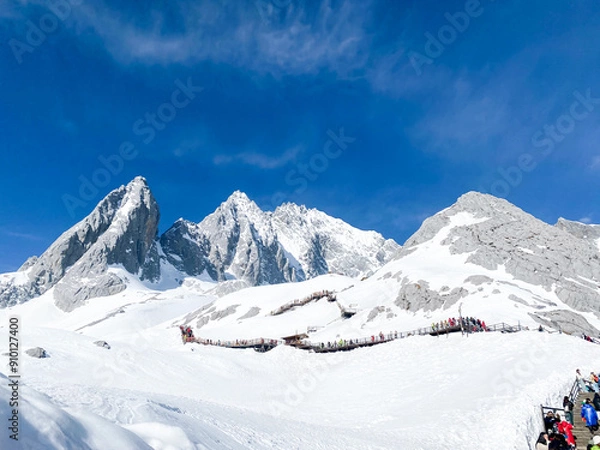 Fototapeta Panoramal nature view Jade Dragon Snow Mountain with soft white cloud on blue sky and soft sunlight in morning, Shangri-La City or Xiang Ge Le La at Yunnan, China