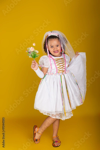 Fototapeta Cheerful child dressed as a bride holding a bouquet of flowers and posing for the camera.