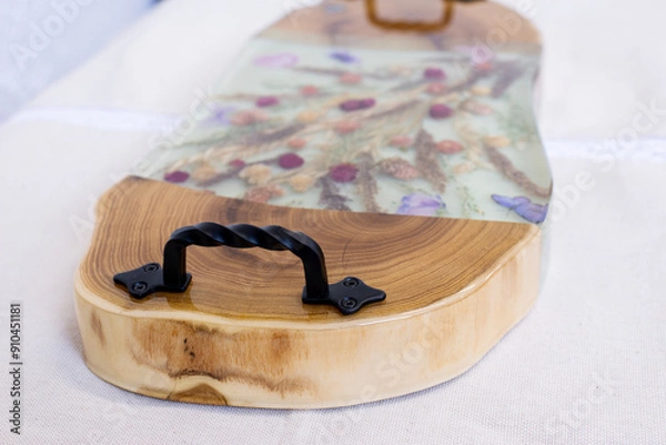 Fototapeta Kitchen board made of wood and epoxy resin. A tray of dried flowers and epoxy. Hand made