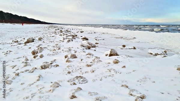 Obraz Snow covered seashore on cold winter day and gray clouds throughout the sky