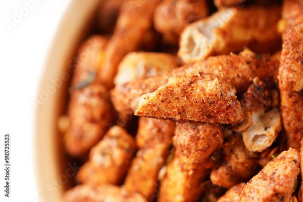 Fototapeta A bowl of Basreng (fried meatballs), a popular Indonesian snack made from thinly sliced fish meatballs, fried until crispy, and coated with spicy seasoning. Photographed against a white background.