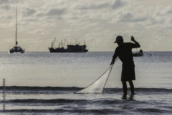 Fototapeta the fisherman he is casting fishing on the seaside