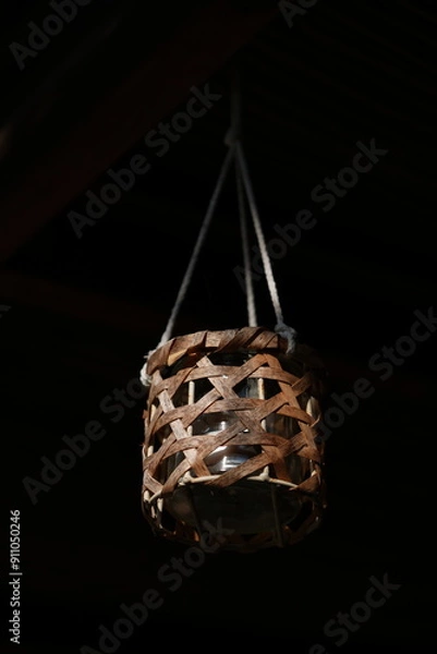 Obraz Candle hanging off rope in darkness