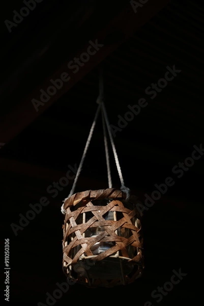 Obraz Candle hanging off rope in darkness
