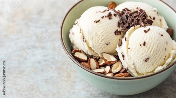 Fototapeta Dairy-free coconut ice cream served in a bowl with chocolate shavings and sliced almonds
