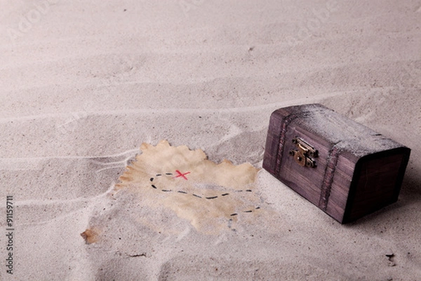 Fototapeta An old chest and a treasure map found in the sand