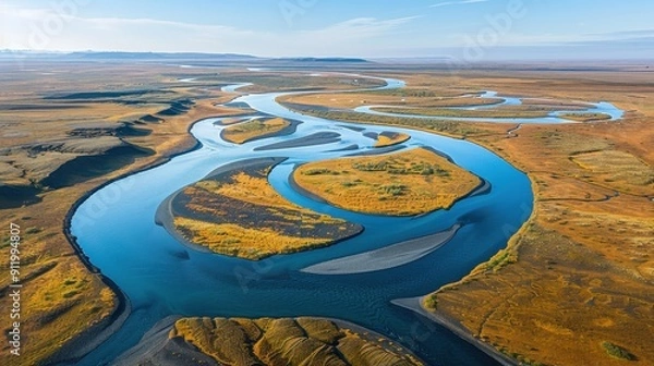 Fototapeta Aerial View of Serpentine River Flowing Through Vibrant Autumn Landscape with Clear Blue Sky