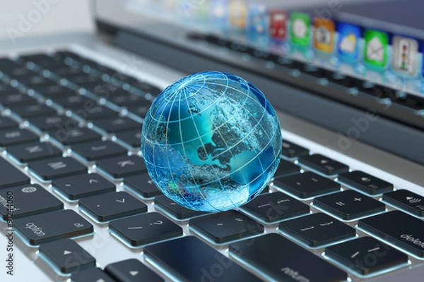 Obraz Globalna komunikacja w sieci komputerowej, biznes internetowy i koncepcja marketingowa, niebieski przezroczysty glob ziemski na widoku makra klawiatury laptopa