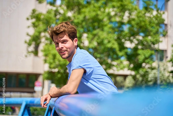 Obraz portrait of a man looking at a camera leaning against the camera