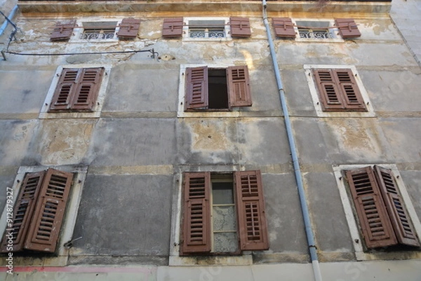 Fototapeta A large structure featuring numerous windows and shutters adorning it