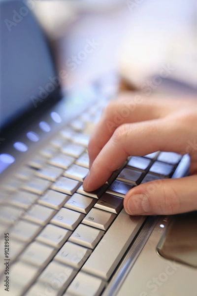 Fototapeta Close up of male hand typing keying on laptop computer keyboard