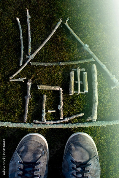 Fototapeta Aerial view of sticks arranged on grass to form geometric shapes and letters, showcasing outdoor creativity and nature art.