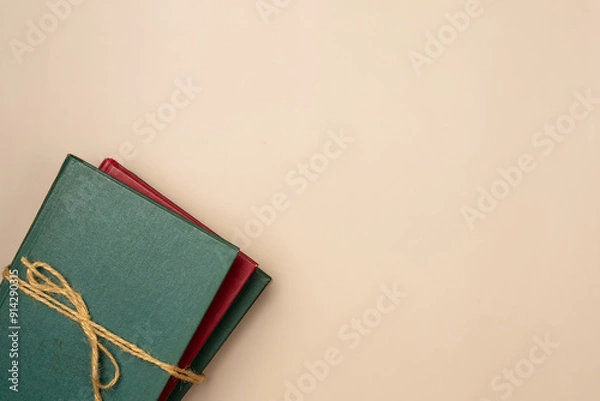 Fototapeta Stack of books on a beige background. Leisure concept, reading a book. Copy space. Flat lay, top view