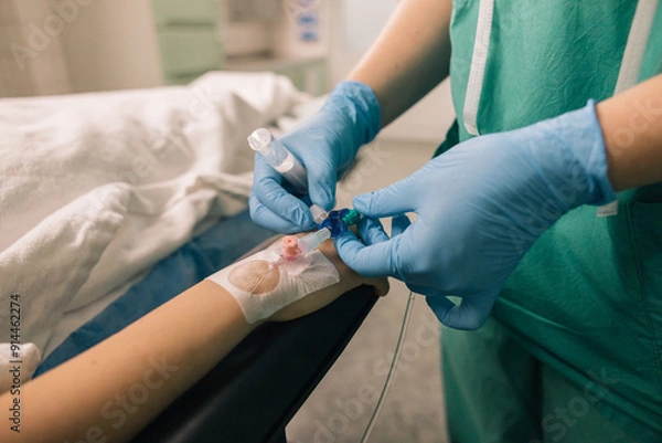 Fototapeta Venous access being established in a patient’s hand by a medical professional