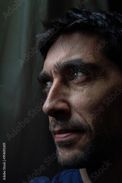 Obraz rostro sonriente con mirada lateral sobre fondo oscuro 