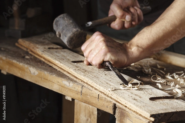 Fototapeta carpenter hands working with a chisel and hammer