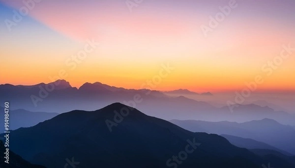 Obraz Serene mountain landscape at sunset with layered silhouettes of hills and distant peaks against a colorful sky