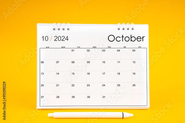 Fototapeta October 2024, Monthly desk calendar for 2024 year and pen on yellow background.