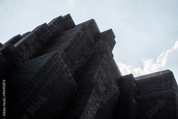 Fototapeta The image shows the modern Gdańsk theater building with its distinctive architectural design against a backdrop of a cloudy sky.