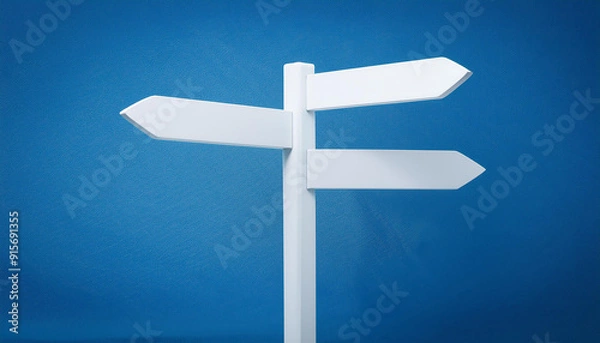 Fototapeta White direction sign on blue background. Pointing arrow. Close-up.