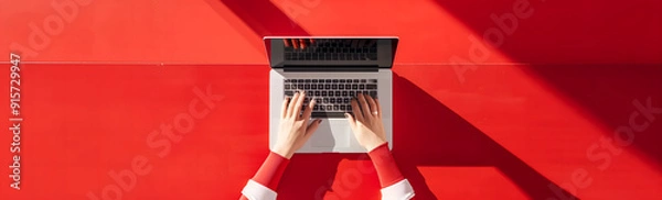 Fototapeta Hands top view typing on laptop with white screen placed against a RED background Laptop Work Background Concept