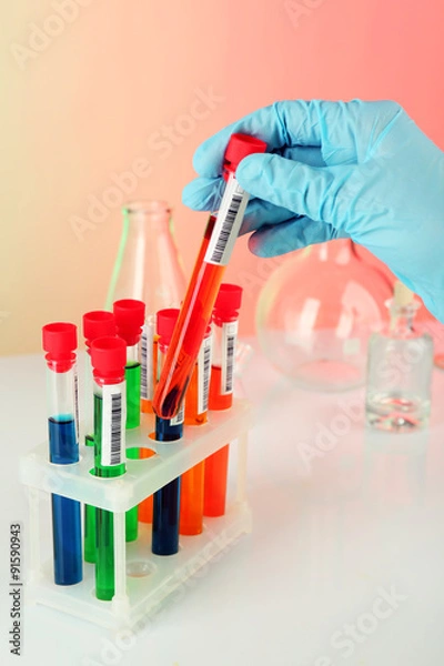Fototapeta Test tubes with colorful liquid in scientist hand, closeup
