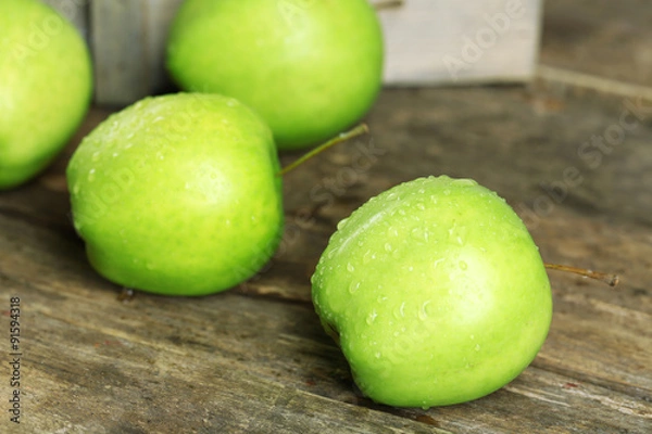 Fototapeta Ripe green apples on wooden table close up