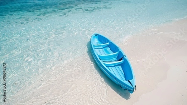 Fototapeta A vibrant blue kayak resting on a pristine beach, surrounded by clear turquoise water, perfect for tropical adventure.