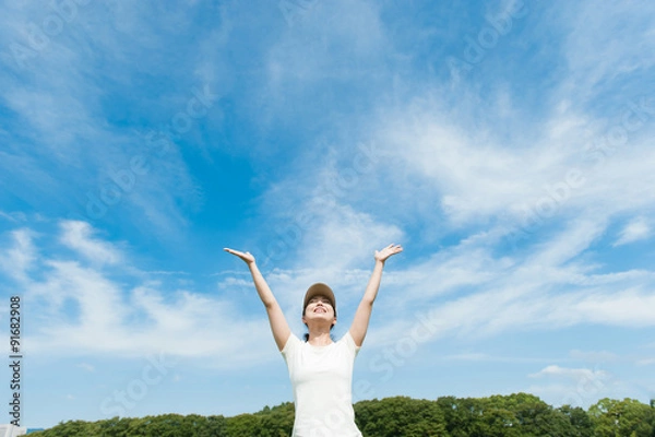 Fototapeta 空に向かって手を広げる女性