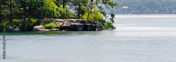 Obraz Panorama of a rock-lined island in the St. Lawrence River surrounded by silky smooth water