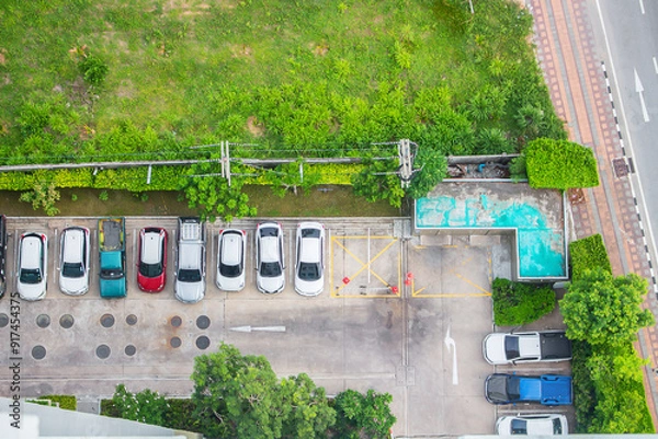 Fototapeta Top view of parking area with small garden in modern building.
