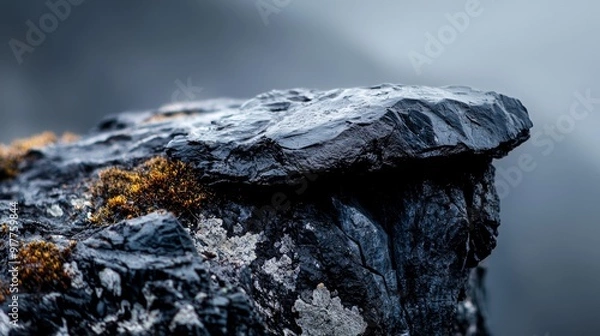 Fototapeta  A rock's textured side, adorned with moss, against a backdrop of a dark, ominous sky