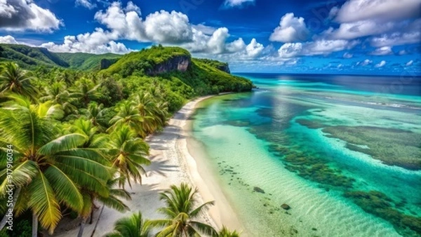 Fototapeta Sandy white beach meets crystal-clear turquoise water along the scenic coastline of Guam Island, surrounded by lush green tropical foliage and swaying palm trees.