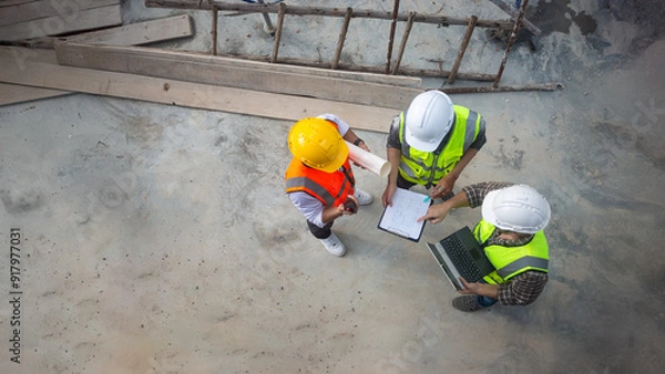Fototapeta Top view of architects engineer are discussing about the progress of the building project and checking the accuracy of the building structure.