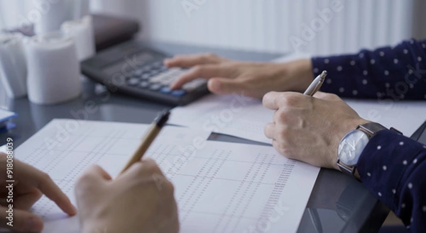 Fototapeta Female accountants or auditors reviewing financial data in office. Professionals analyzing paper reports and using calculator, close up view. Audit and taxes in business