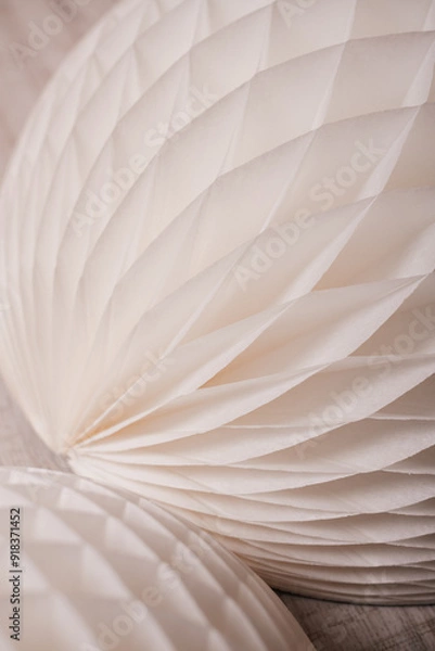 Fototapeta A close-up shot of a white, honeycomb paper decoration, showcasing intricate textures and soft lighting.