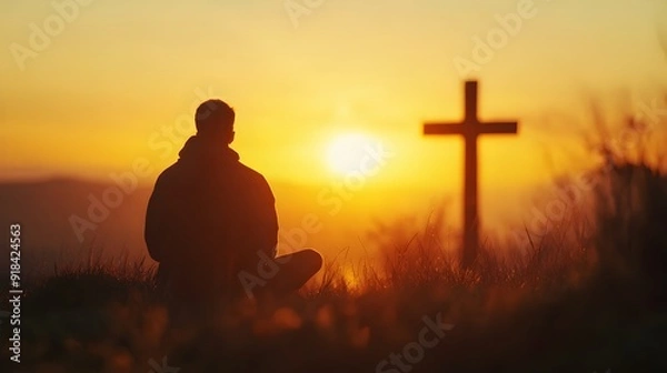Obraz Silhouette of a man sitting in front of a cross at sunset
