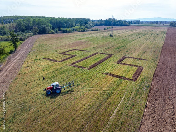 Fototapeta A giant SOS, a symbolic call against excessive land use, written into the ground by a tractor.