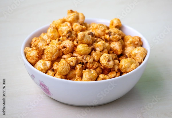 Obraz Bowl of barbecue flavored popcorn on light wooden background.