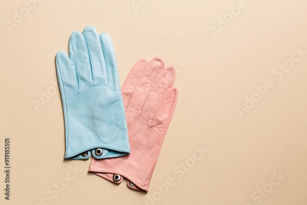 Fototapeta A creative multi-colored pair of gloves on a beige background