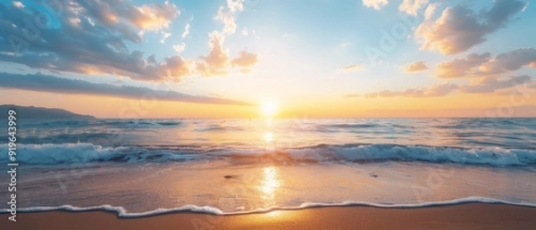 Fototapeta  The sun sets over the foamy ocean, waves crash onto the sand