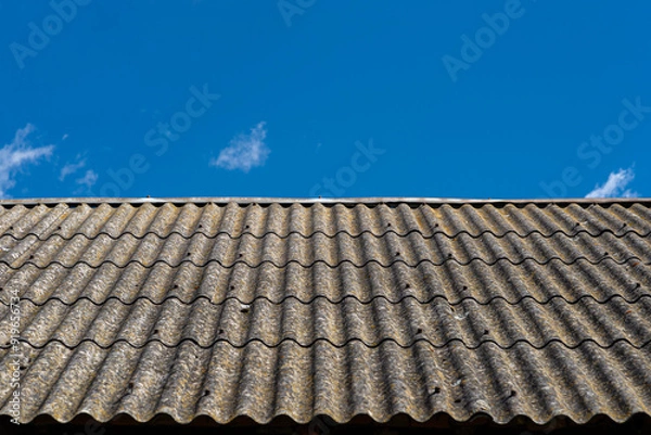 Obraz An old brick barn in the Polish countryside with a corrugated asbestos roof.